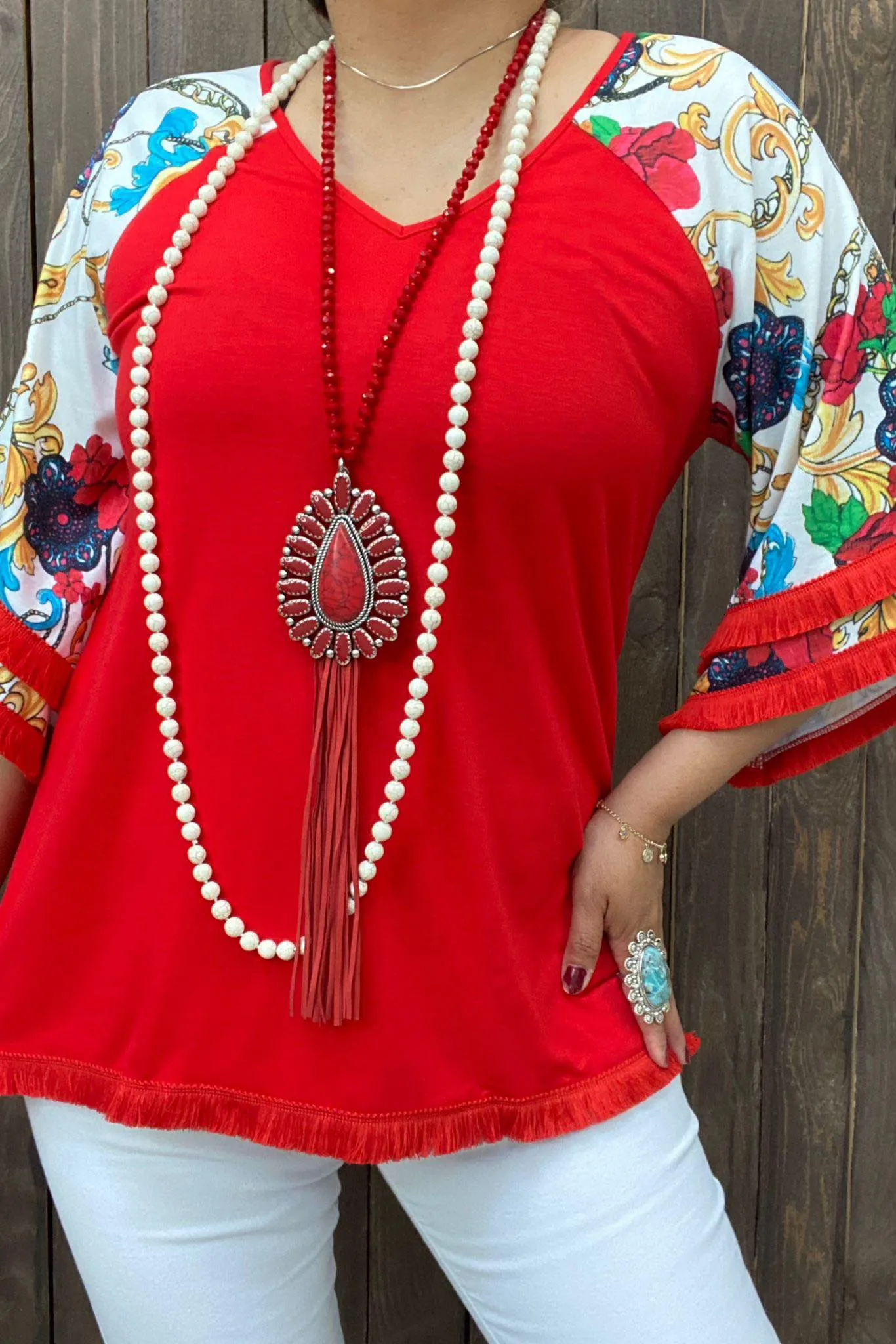 Red Top with white design bell sleeves and fringe trim