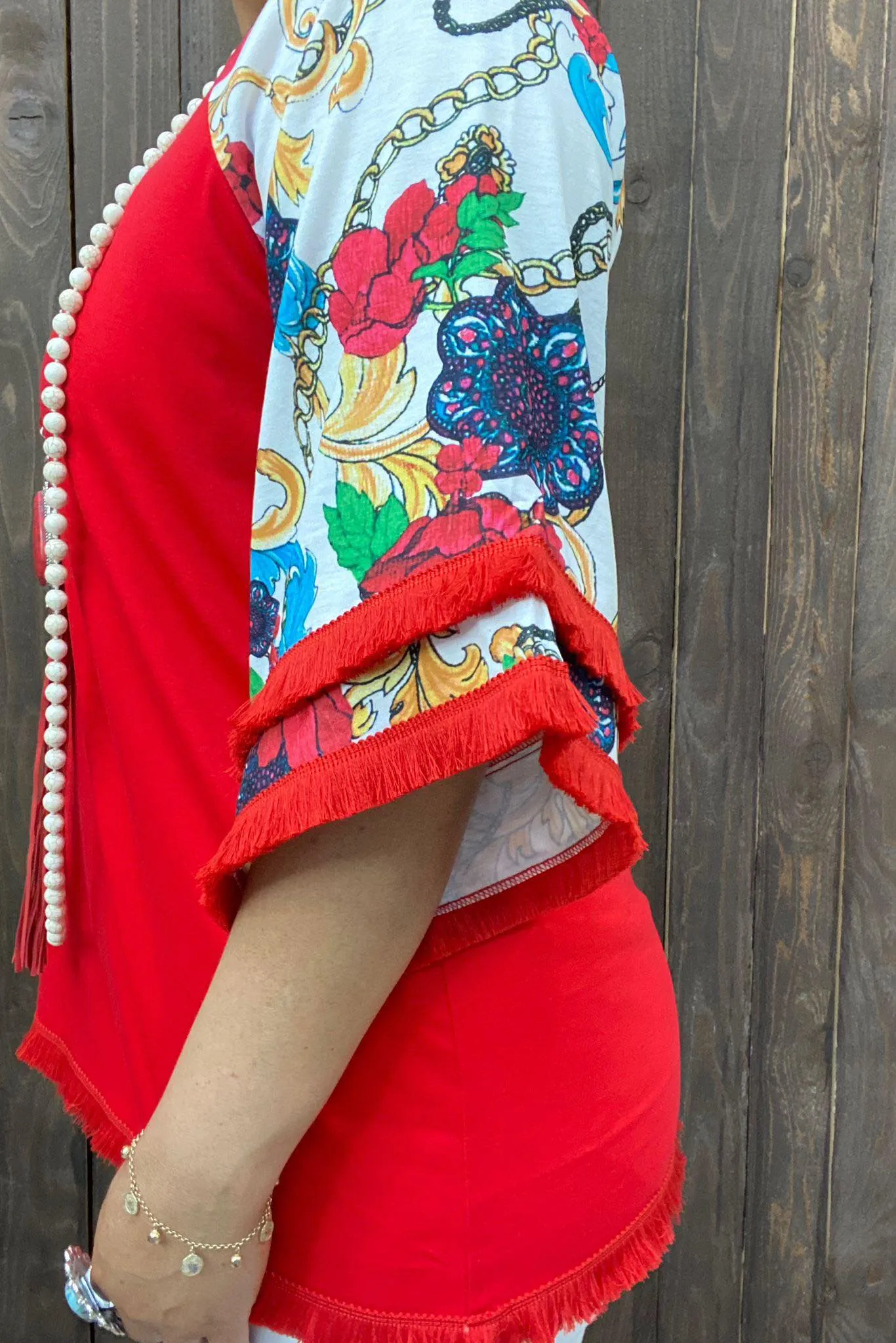 Red Top with white design bell sleeves and fringe trim